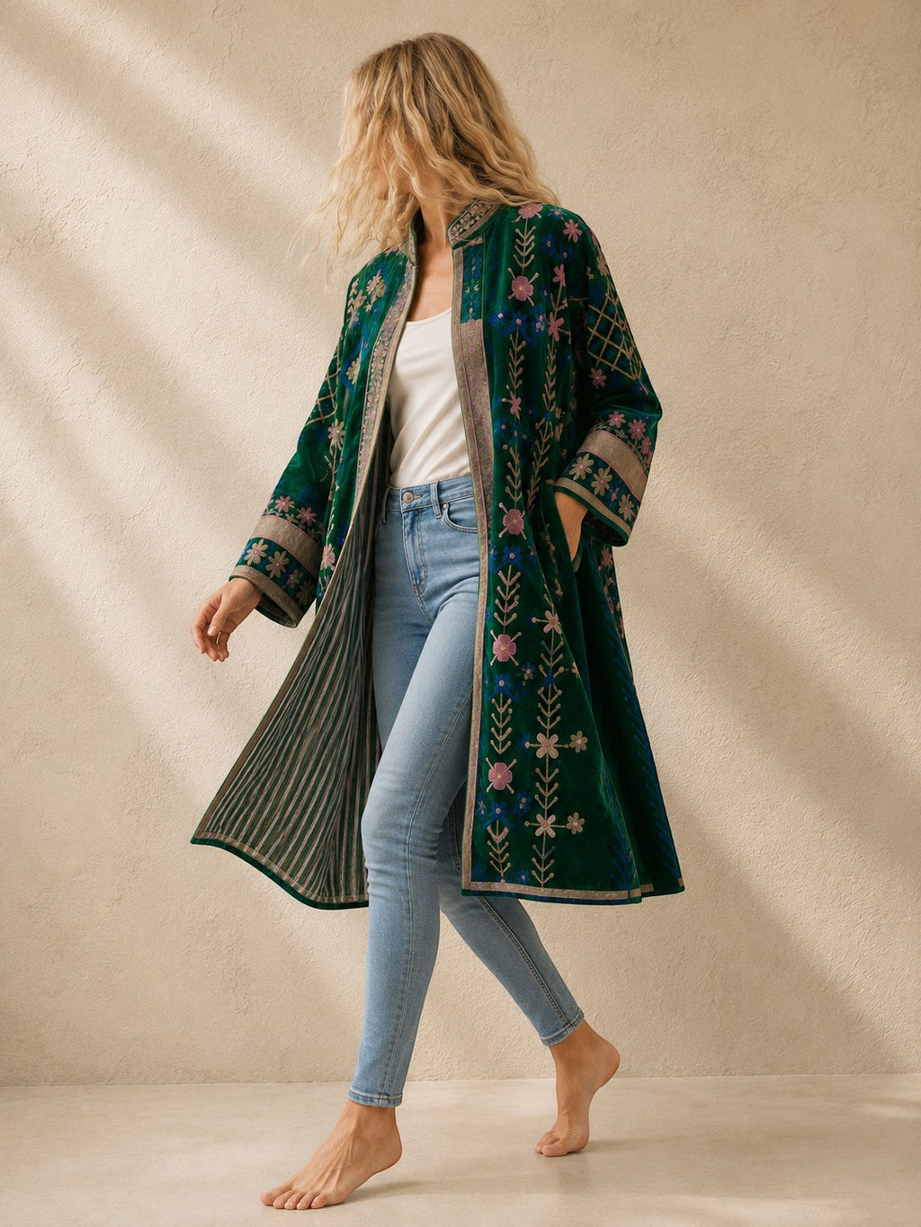 The House of Saffron long green velvet suzani jacket with intricate floral embroidery and striped lining on a model.
