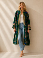 The House of Saffron long green velvet suzani jacket with intricate floral embroidery and heart-stitched border details.