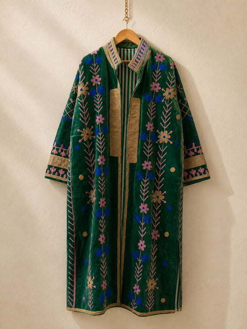 The House of Saffron long green velvet jacket featuring intricate floral suzani embroidery and a striped cotton lining.