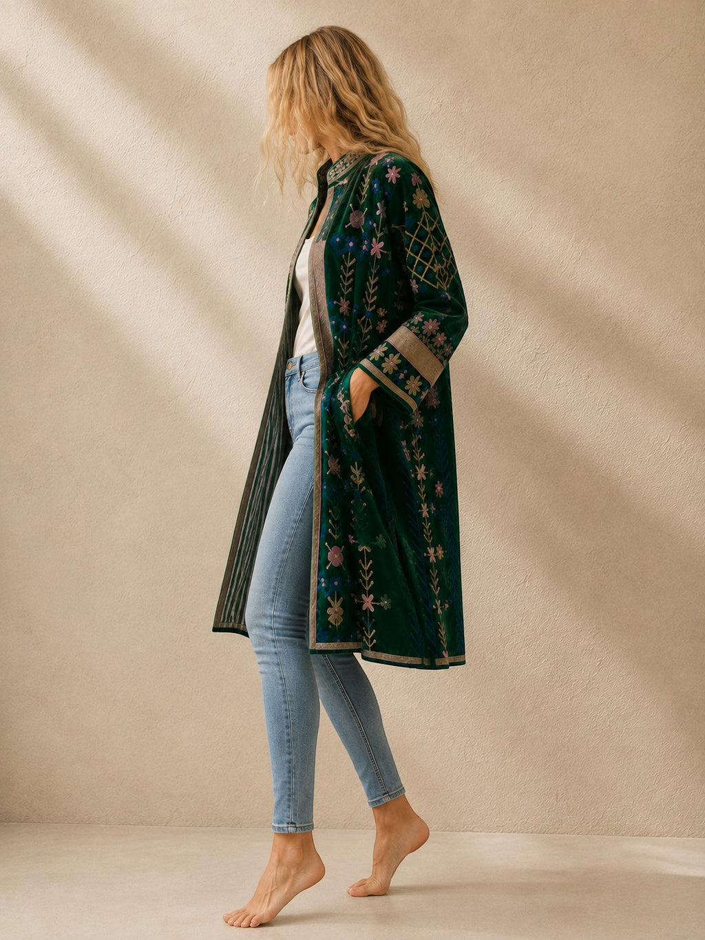 The House of Saffron long indigo velvet suzani jacket with intricate floral embroidery and side pockets on a model.