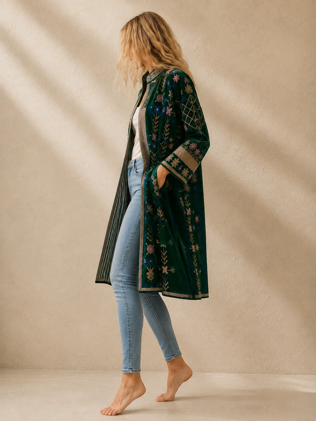 The House of Saffron long indigo velvet suzani jacket with intricate floral embroidery and side pockets on a model.