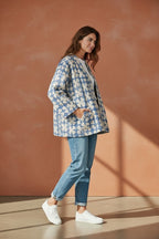 The House of Saffron reversible blue and white quilted cotton Kantha jacket with patch pockets worn by a model.
