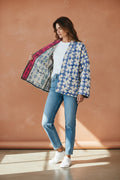Model wearing The House of Saffron reversible cotton Kantha jacket with blue floral print and pink patterned lining.