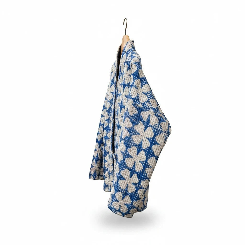 The House of Saffron reversible cotton Kantha jacket in blue and white floral print hanging on a wooden hanger