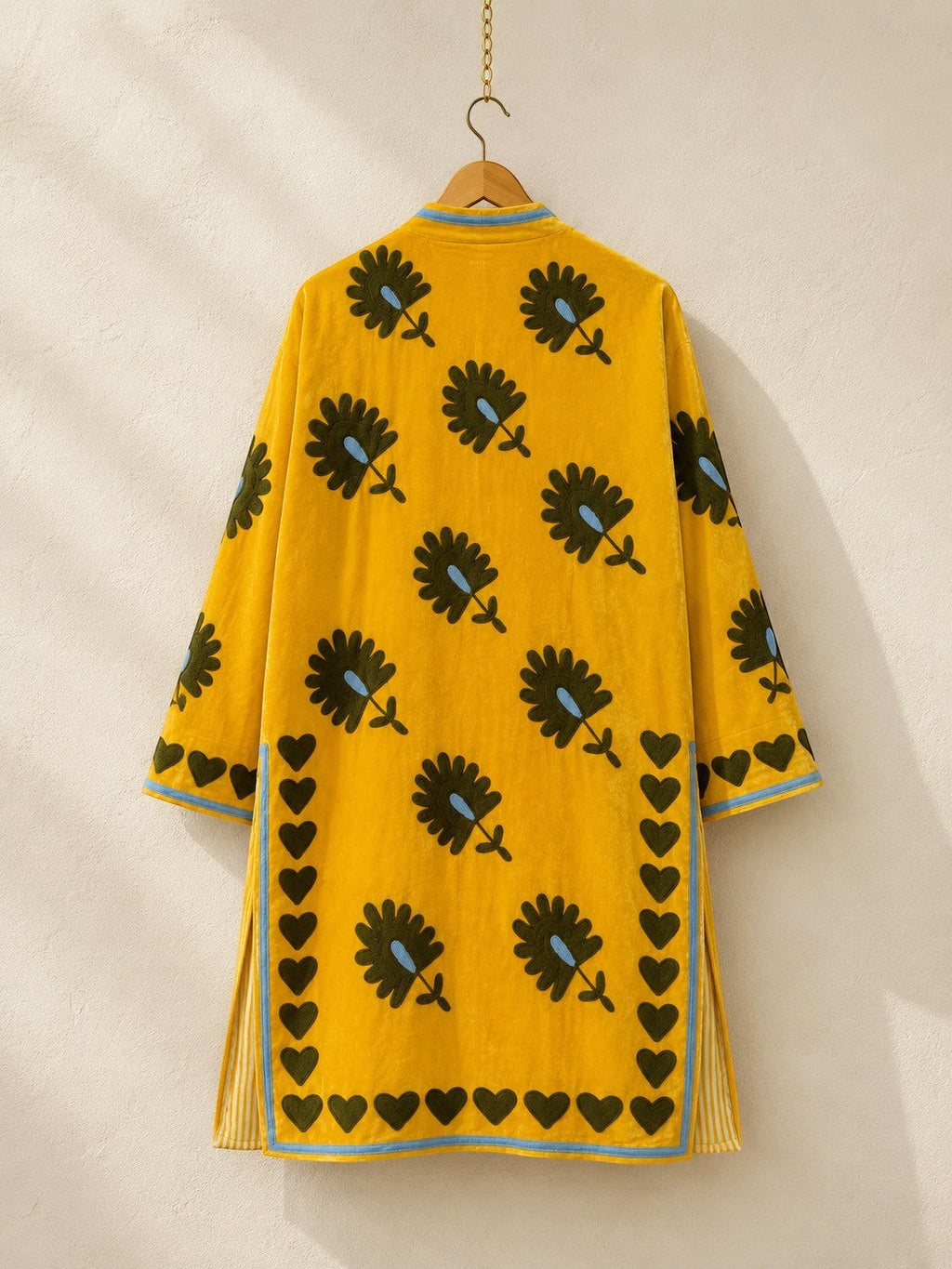 The House of Saffron long saffron velvet jacket featuring dark floral embroidery and a hand-stitched heart border.