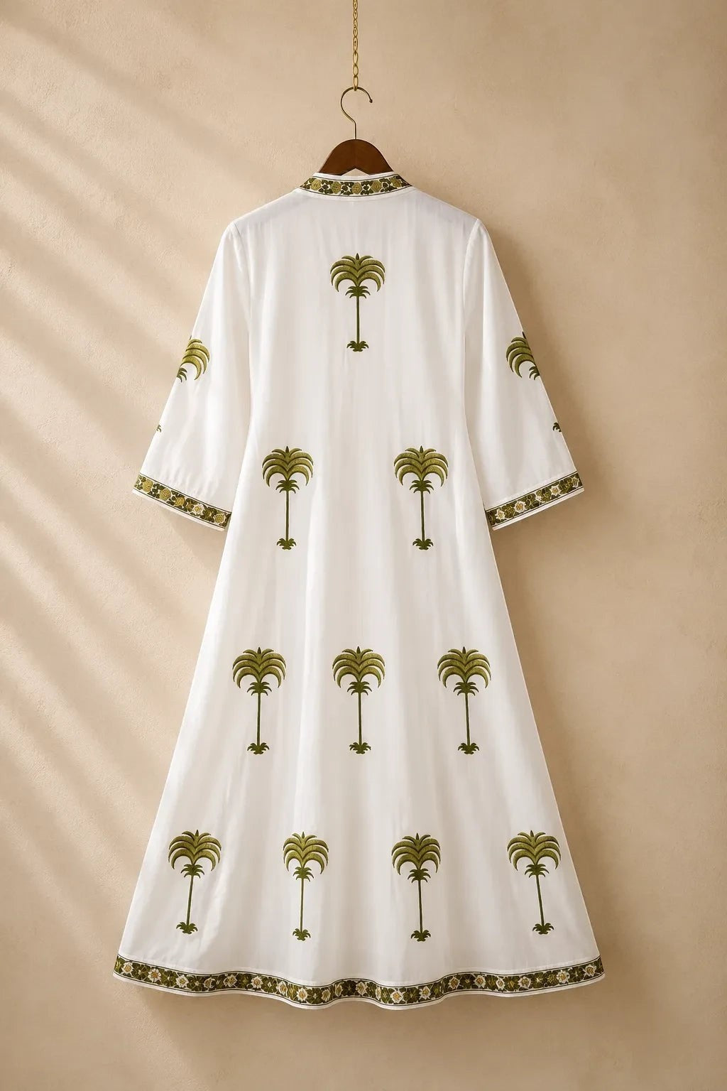The House of Saffron white kaftan featuring olive green palm tree embroidery, V-neckline, and three-quarter sleeves.